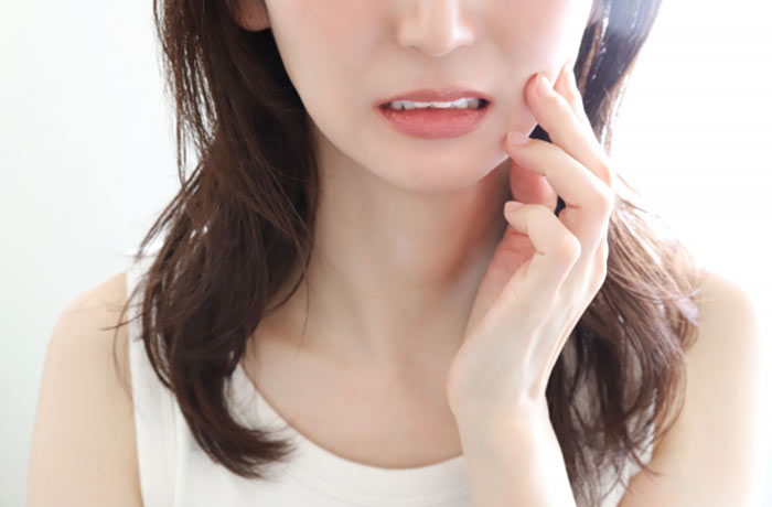 夏休み中の歯痛を防ぐため事前に歯科受診を検討する女性
